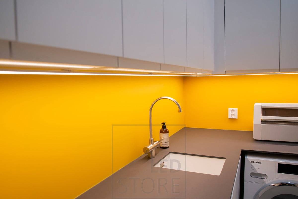 Espace coloré dans la buanderie éclairé par une bande de LED dans un profil de surface